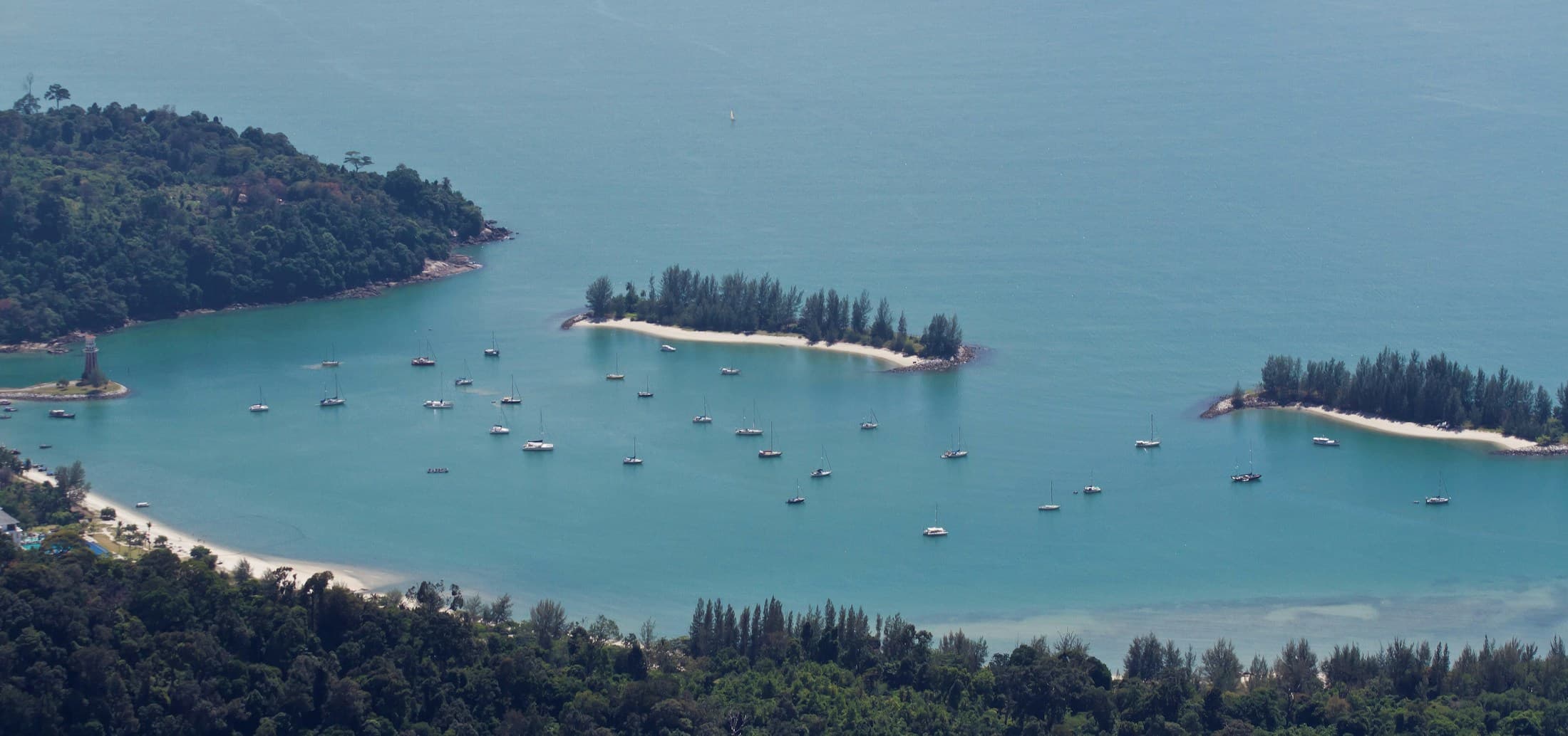 Aerial view of rainforest-covered islands and turquoise water in Langkawi